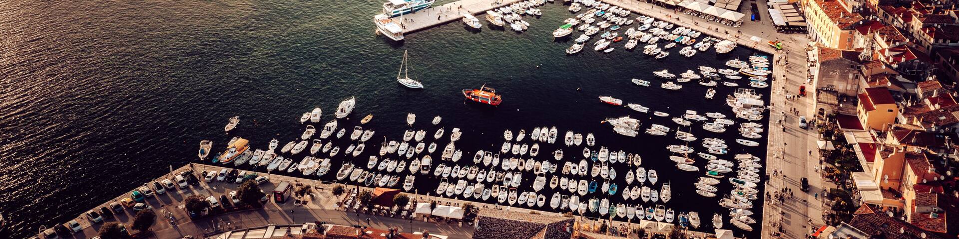 Aerial view of a picturesque coastal town crowned by the steeple of St. Euphemia Church, where terracotta rooftops meet the azure Adriatic, Rovinj, Istria County, Croatia.