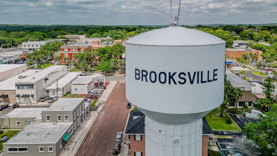 A water tower labeled 'BROOKSVILLE' with a view of the town's streets and buildings.