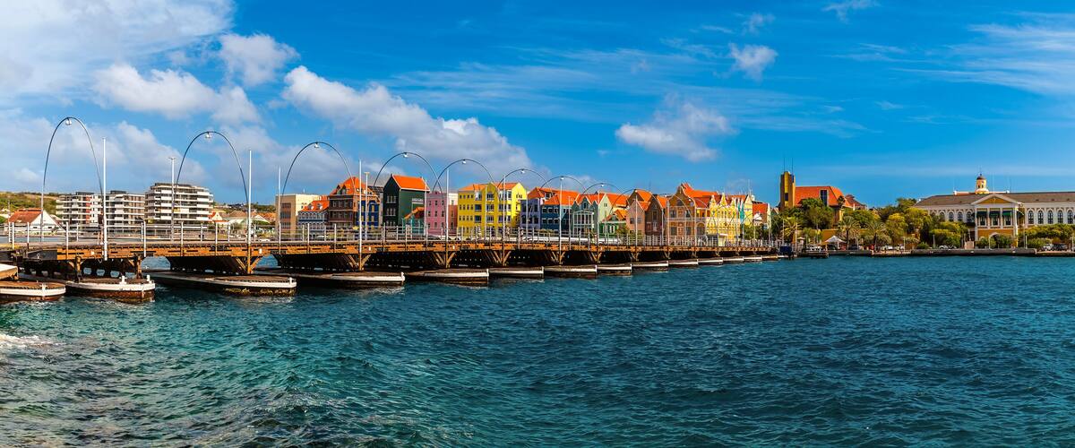 A panorama view across the Queen Emma Bridge over Saint Anna Bay towards the Punda District in Willemstad, Curacao on a bright morning