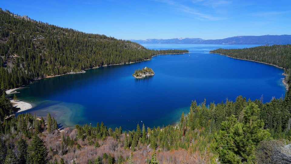 A large lake surrounded by dense forests and mountains.
