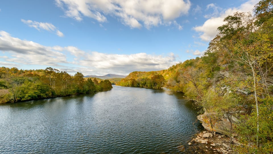 A river winding through a forested valley with autumn foliage.