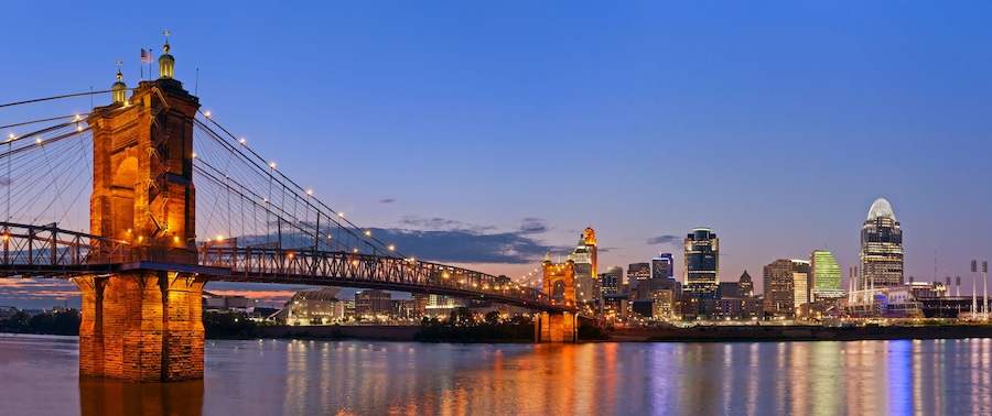 A bridge spanning a river with a city skyline in the background.