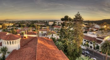 A coastal cityscape with Mediterranean architecture, palm trees, and a clear sky.