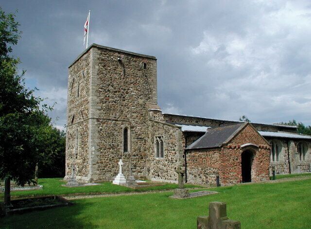 A stone church with a bell tower and a small adjacent building.