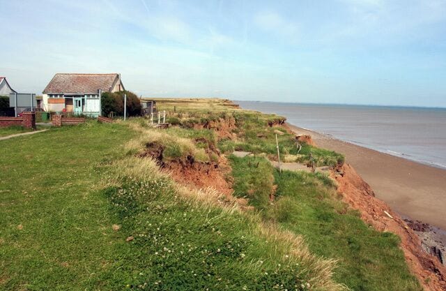 Road crumbling into the sea at Aldbrough, East Riding of Yorkshire, England. Empty house and a road falling away to the beach at Mount Pleasant Aldbrough.