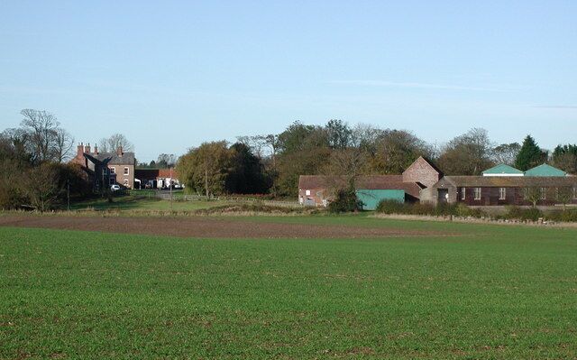Bewick Hall, Aldbrough, East Riding of Yorkshire, England. Looking west-northwest from Withernwick Road at Cony Garth Hill, northwest of Aldbrough. The name Bewick is an Anglo-Scandinavian hybrid meaning 'dairy farm near the bees'. The present Bewick Hall is an 18th-century building which was remodelled in the later 19th century and incorporates materials from an earlier house. The medieval manor house is thought to have stood on a moated site just west of the newer building.