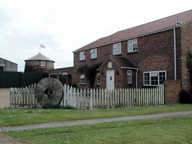 Havenside Windmill, Patrington, East Riding of Yorkshire, England. Like many English buildings at this time, the truncated windmill flies the flag of St. George on a day when England will play Trinidad & Tobago in the FIFA World Cup. A plaque above the door to Mill House says it was built in 1810.