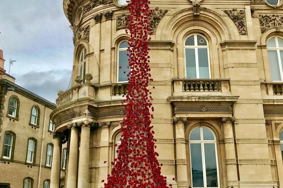 Ein großes Gebäude mit aufwendiger Architektur und einer hohen Säule aus roten Blumen.