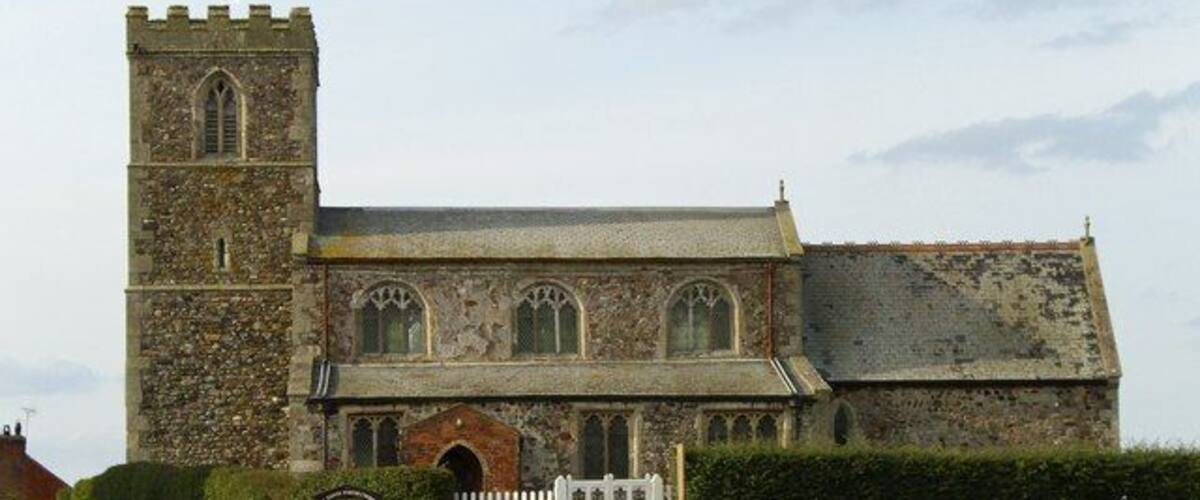 A historic stone church with a bell tower and arched windows.