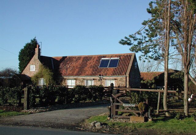A rustic stone house with a sloped roof and a solar panel.