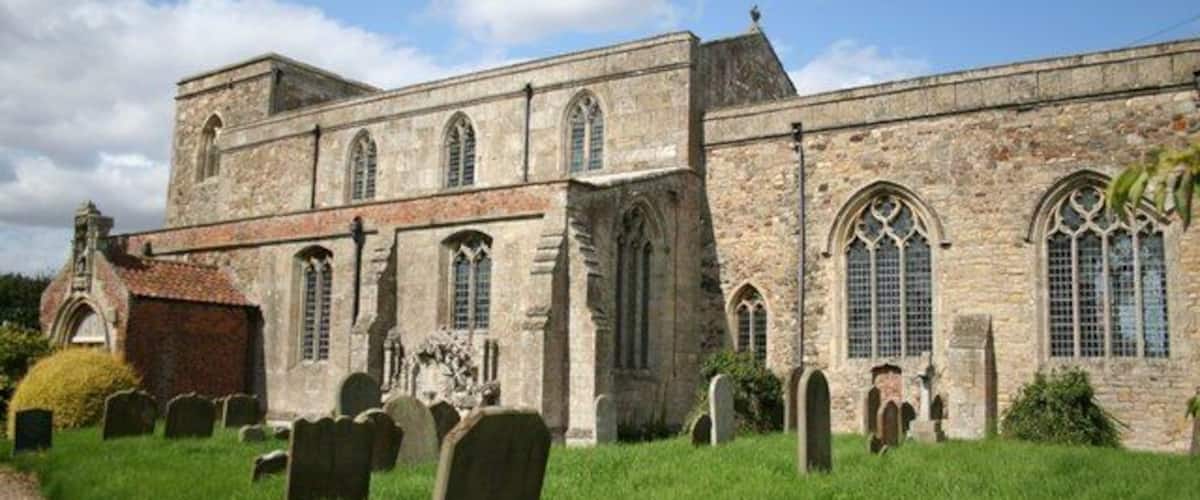 A historic church with a graveyard in front.