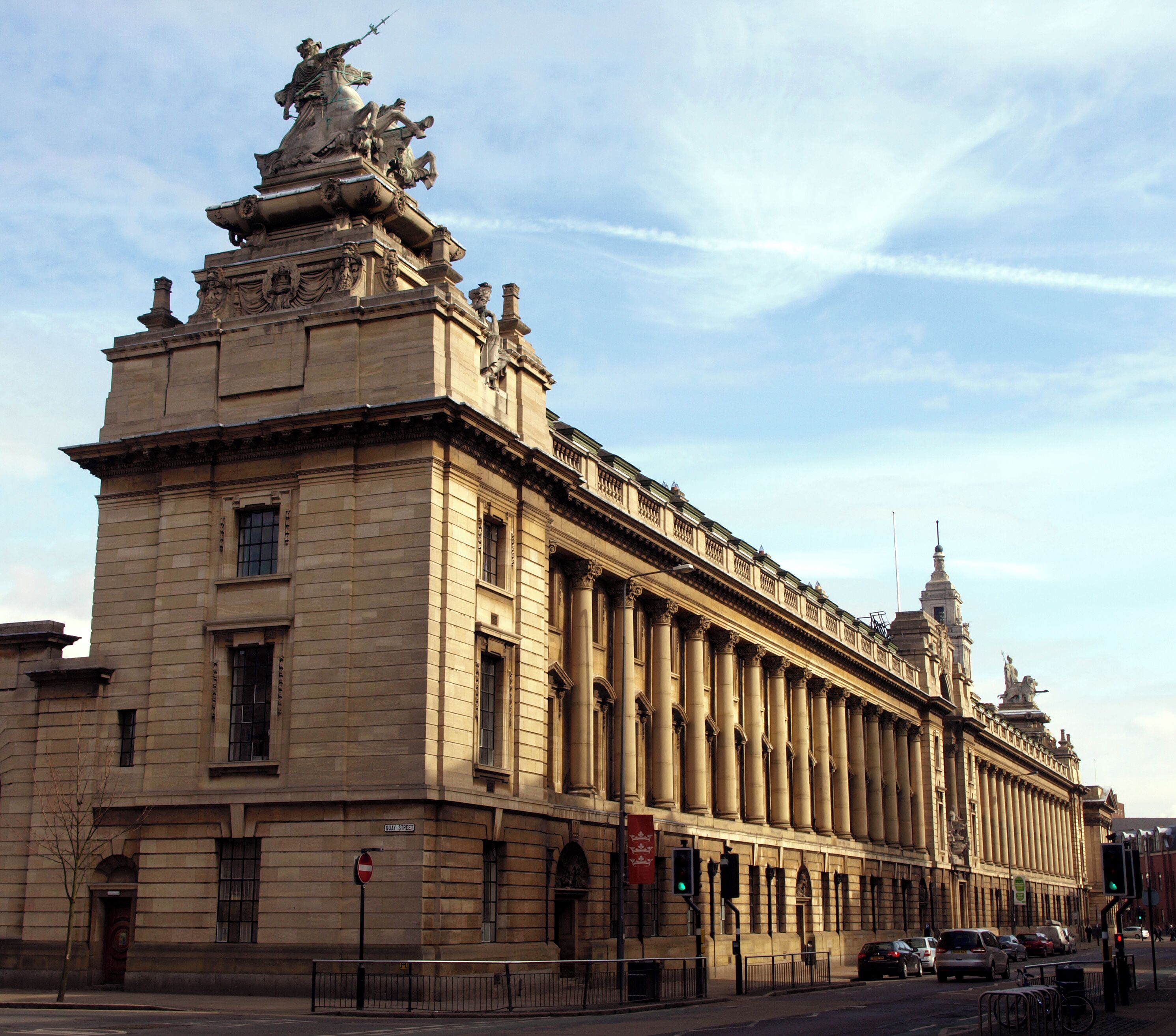 A large, historic building with classical architecture, including columns and statues.