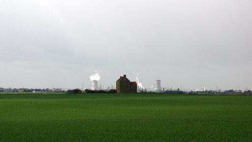 Twin towers on the New York skyline, Burstwick, East Riding of Yorkshire, England. The derelict farmhouse at New York, Burstwick, flanked on the horizon by the cooling towers at Salt End chemical works.