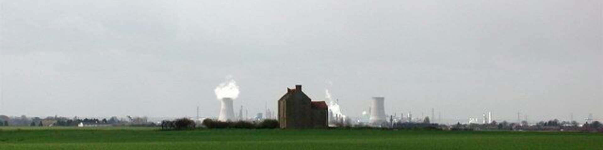 Twin towers on the New York skyline, Burstwick, East Riding of Yorkshire, England. The derelict farmhouse at New York, Burstwick, flanked on the horizon by the cooling towers at Salt End chemical works.
