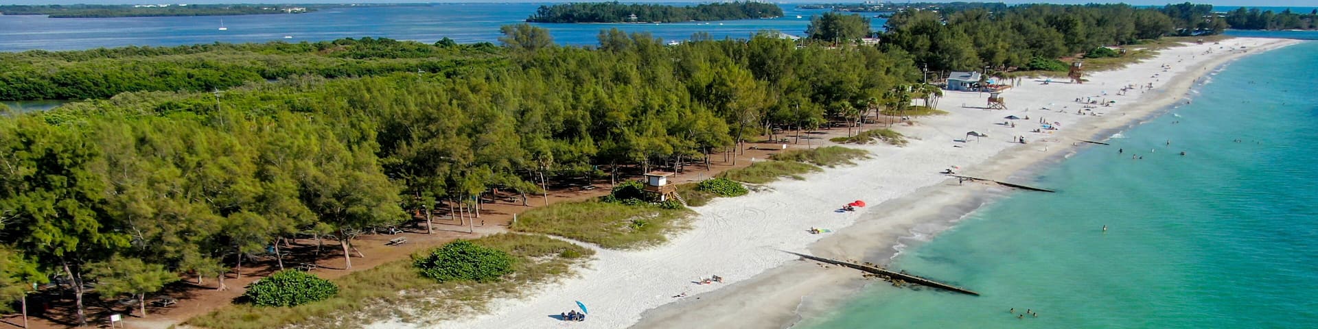 Aerial view of Coquina Beach white sand beach and turquoise water in Bradenton Beach during blue summer day, Anna Maria Island, Florida. USA