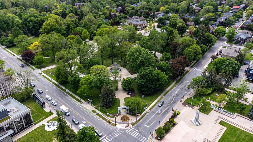An aerial view of a residential area with a park, a gazebo, and a monument.