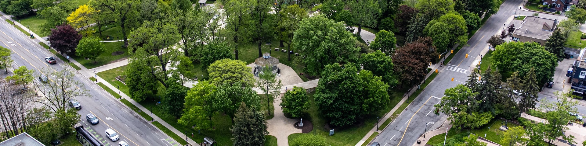 Eine Vogelperspektive eines Wohngebiets mit einem Park, einem Kiosk und einem Denkmal.