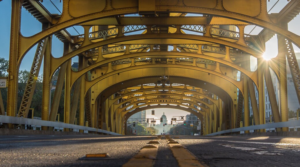 Eine gelbe Stahlbrücke mit einer Straße darunter.