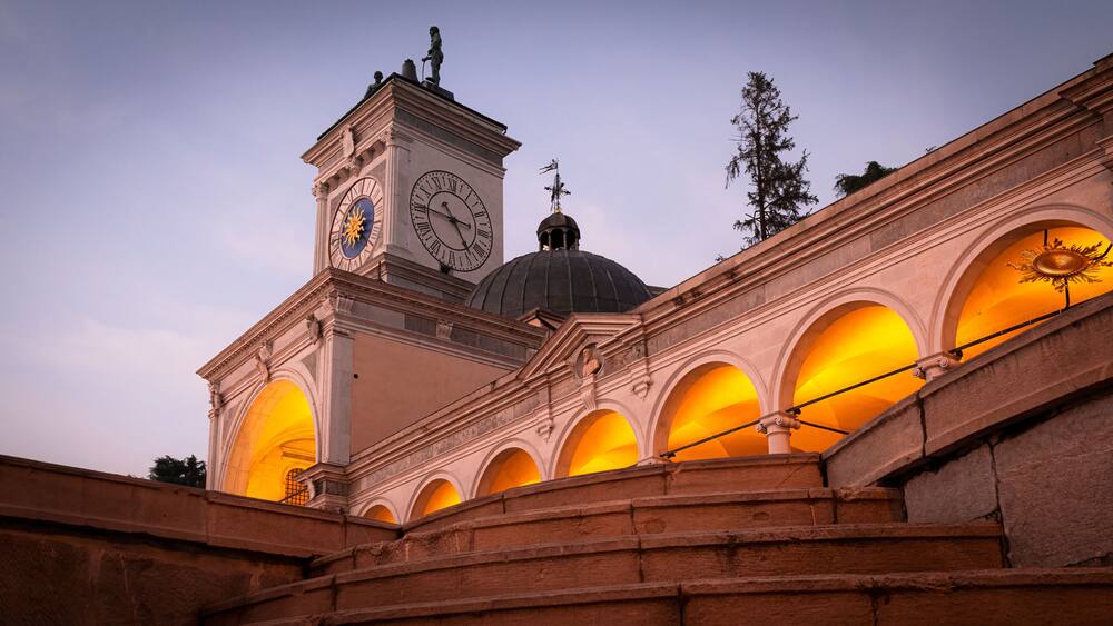 Beautiful classic Italian architecture at sunset. Magnificent clock tower, loggia, arches and colonnade in Udine city, Friuli Venezia Giulia region, Italy.