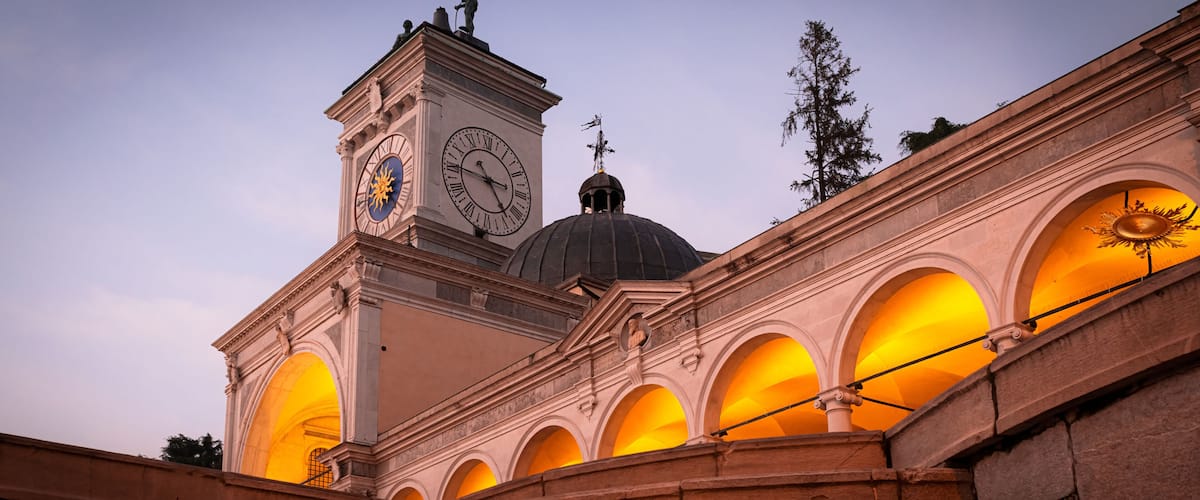 Beautiful classic Italian architecture at sunset. Magnificent clock tower, loggia, arches and colonnade in Udine city, Friuli Venezia Giulia region, Italy.