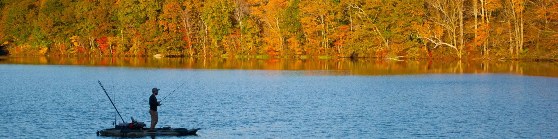 Fishrman in Risley Park Vernon Connecticut during autumn fall with beautfull foliage