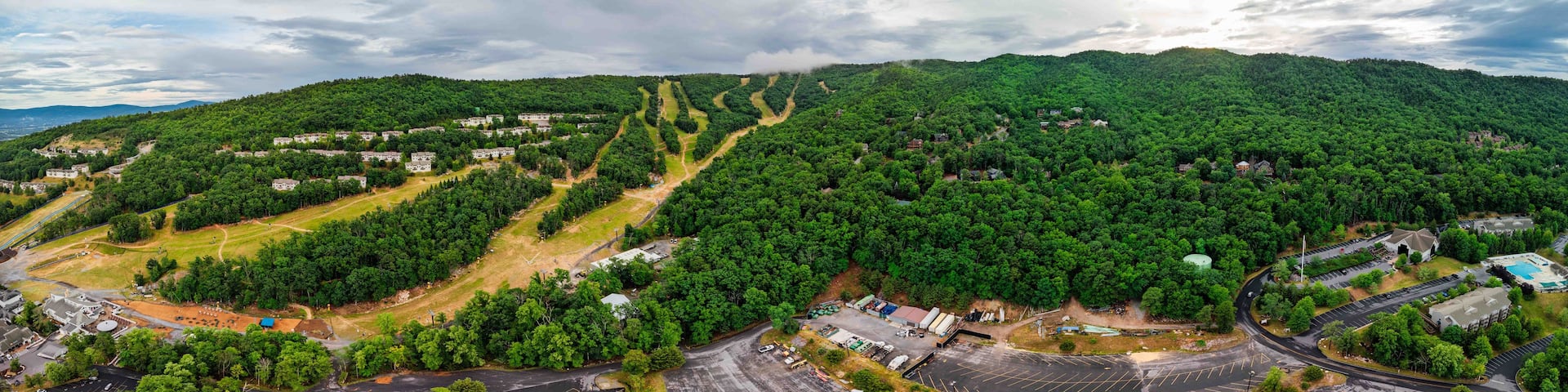 A mountainous landscape with a residential area and a parking lot.