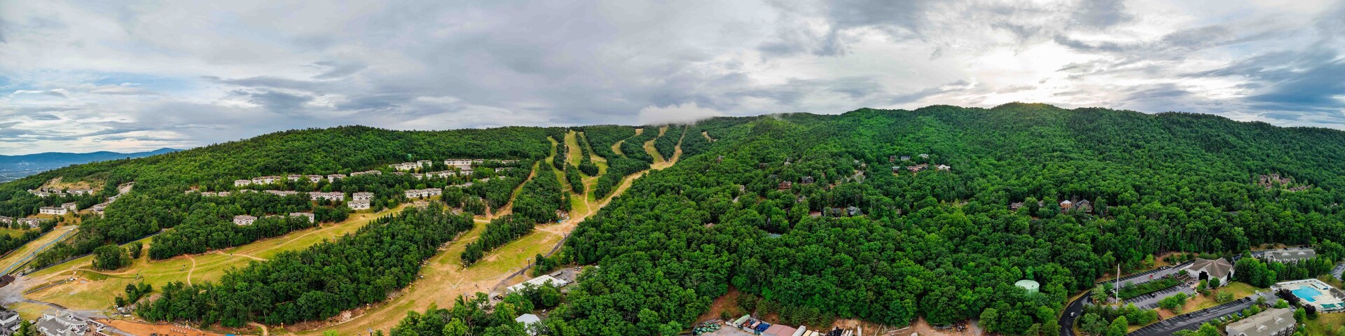 Un paysage montagneux comprenant une zone résidentielle et un parking.