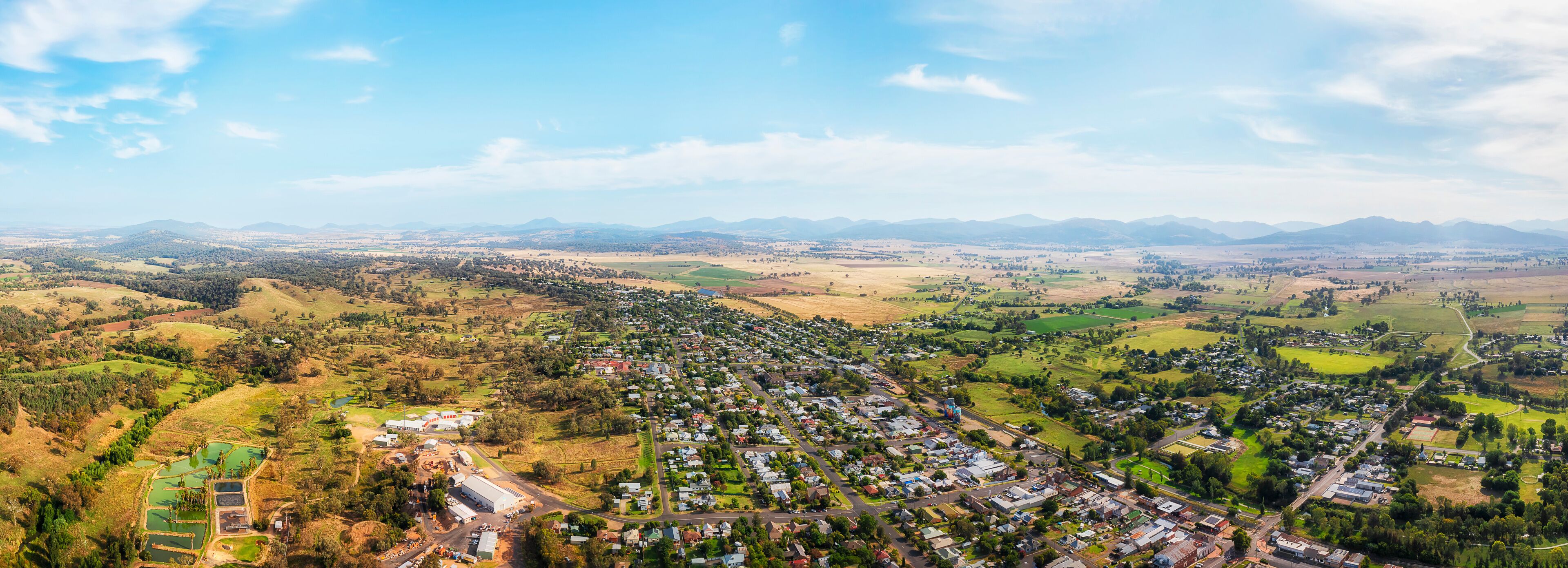 A town nestled in a valley with surrounding hills and mountains.