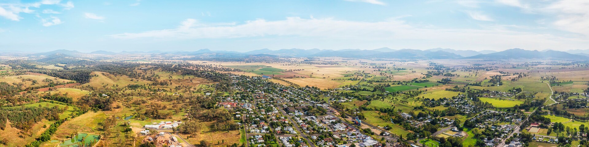 A town nestled in a valley with surrounding hills and mountains.