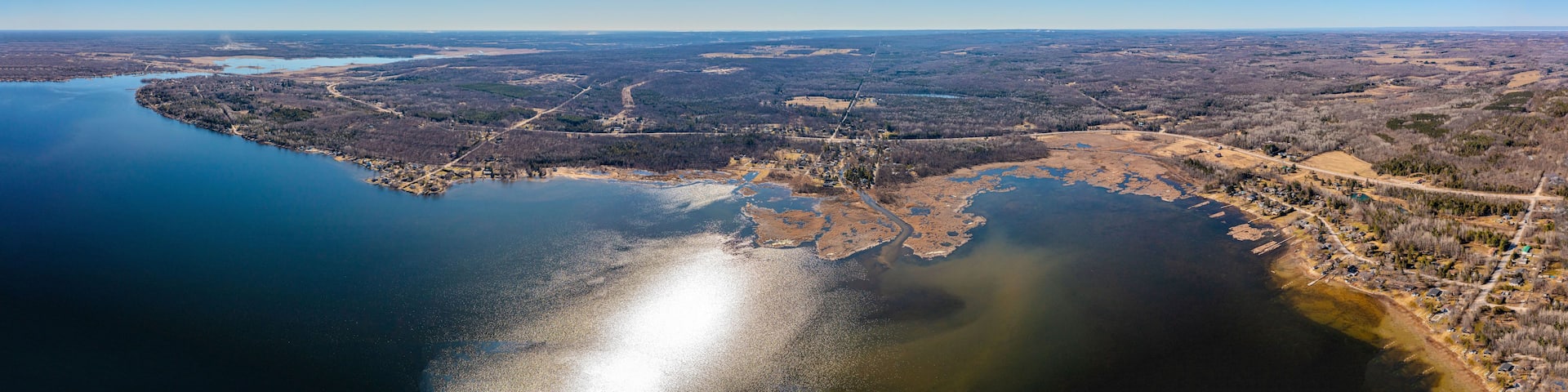 An aerial view of a river delta with a mix of forested areas and open fields.