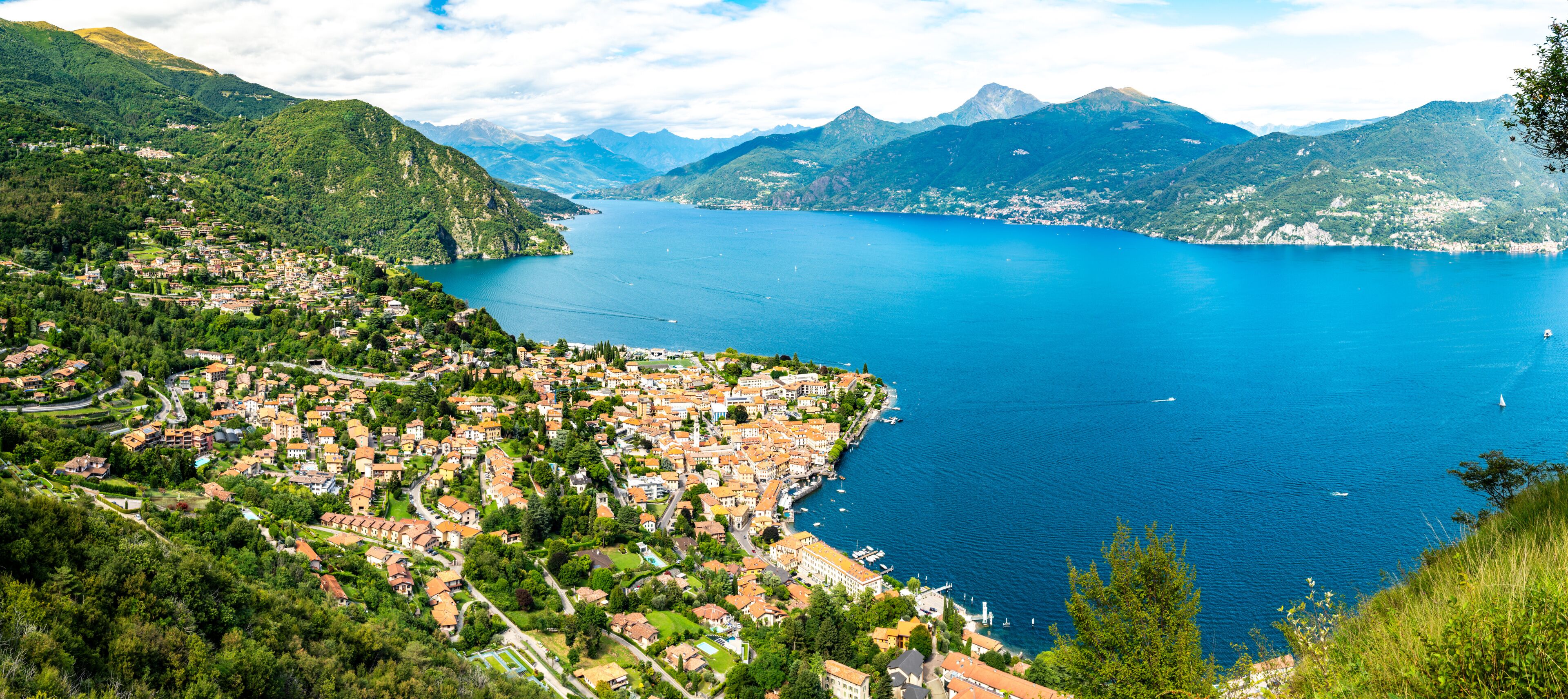 Panorama of Lake Como, photographed from the village of Croce, with the town of Menaggio and the mountains above it.
