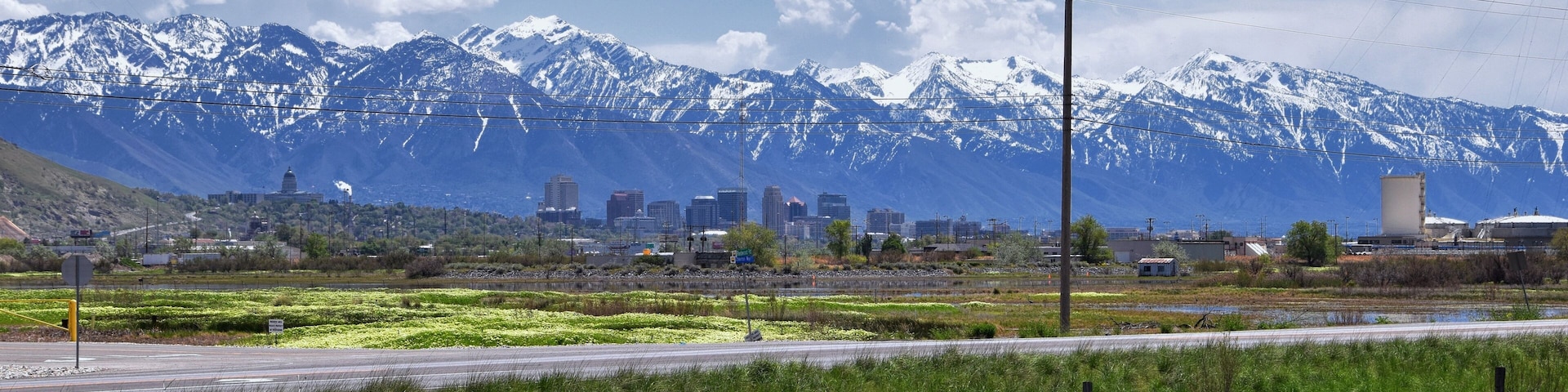 Jordan River Parkway Trail, Redwood Trailhead bordering the Legacy Parkway Trail, panorama views with surrounding trees and silt filled muddy water along the Rocky Mountains, Salt Lake City, Utah.
