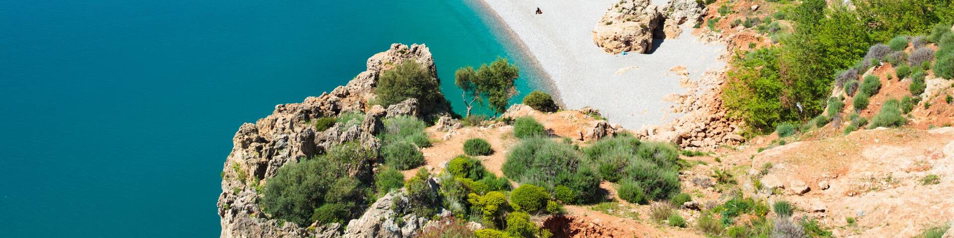 Scenic view of Konyaaltı Beach in Antalya, Turkey, with clear blue waters of Mediterranean Sea and mountains in background. Welcome to Antalya concept image