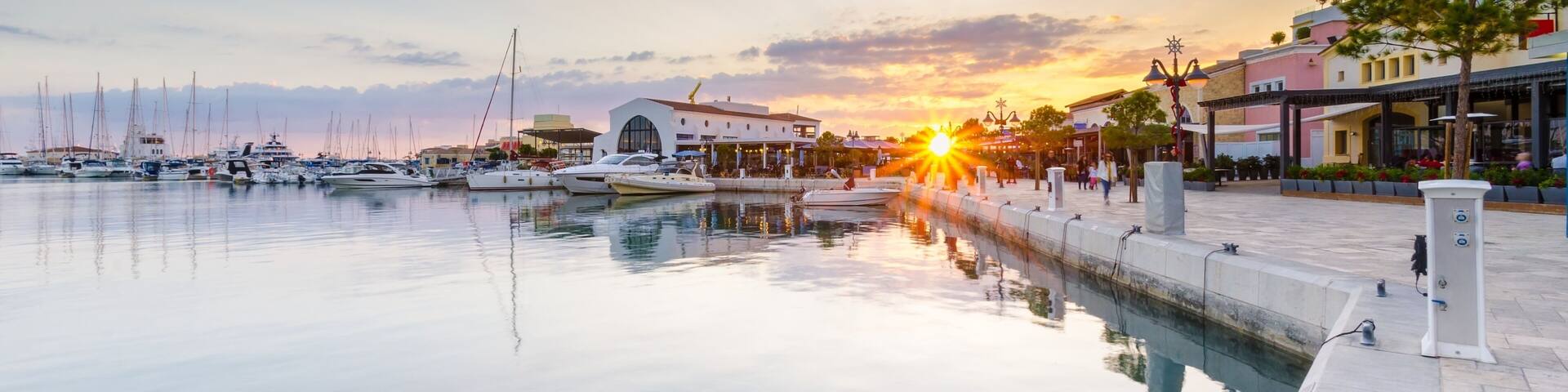 Beautiful Marina, Limassol city Cyprus. Modern, high end life in newly developed port with docked yachts, restaurants, shops, a landmark for waterfront promenade. View of the commercial area at sunset
