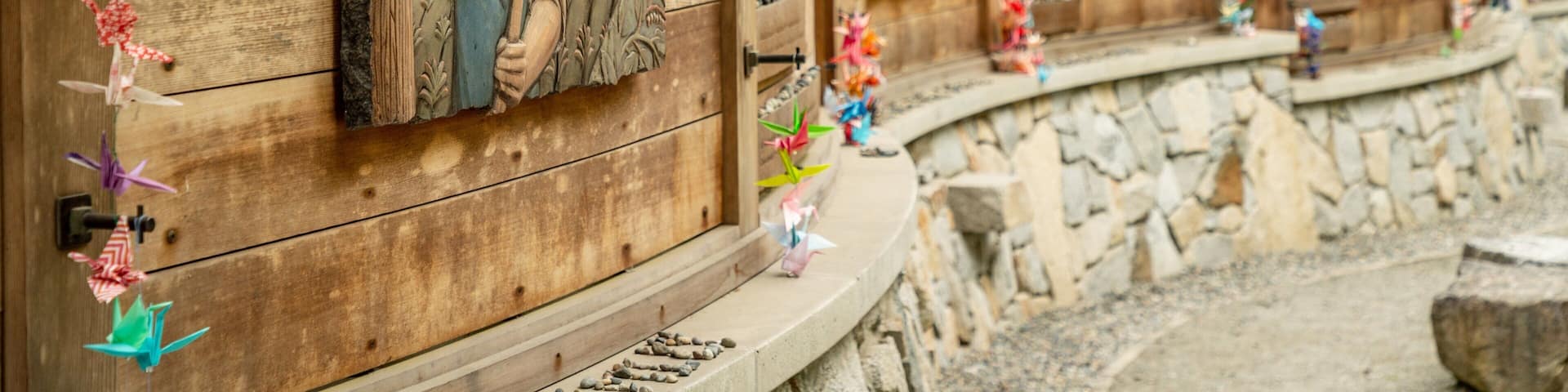 A wooden building with carved figures and colorful paper decorations.