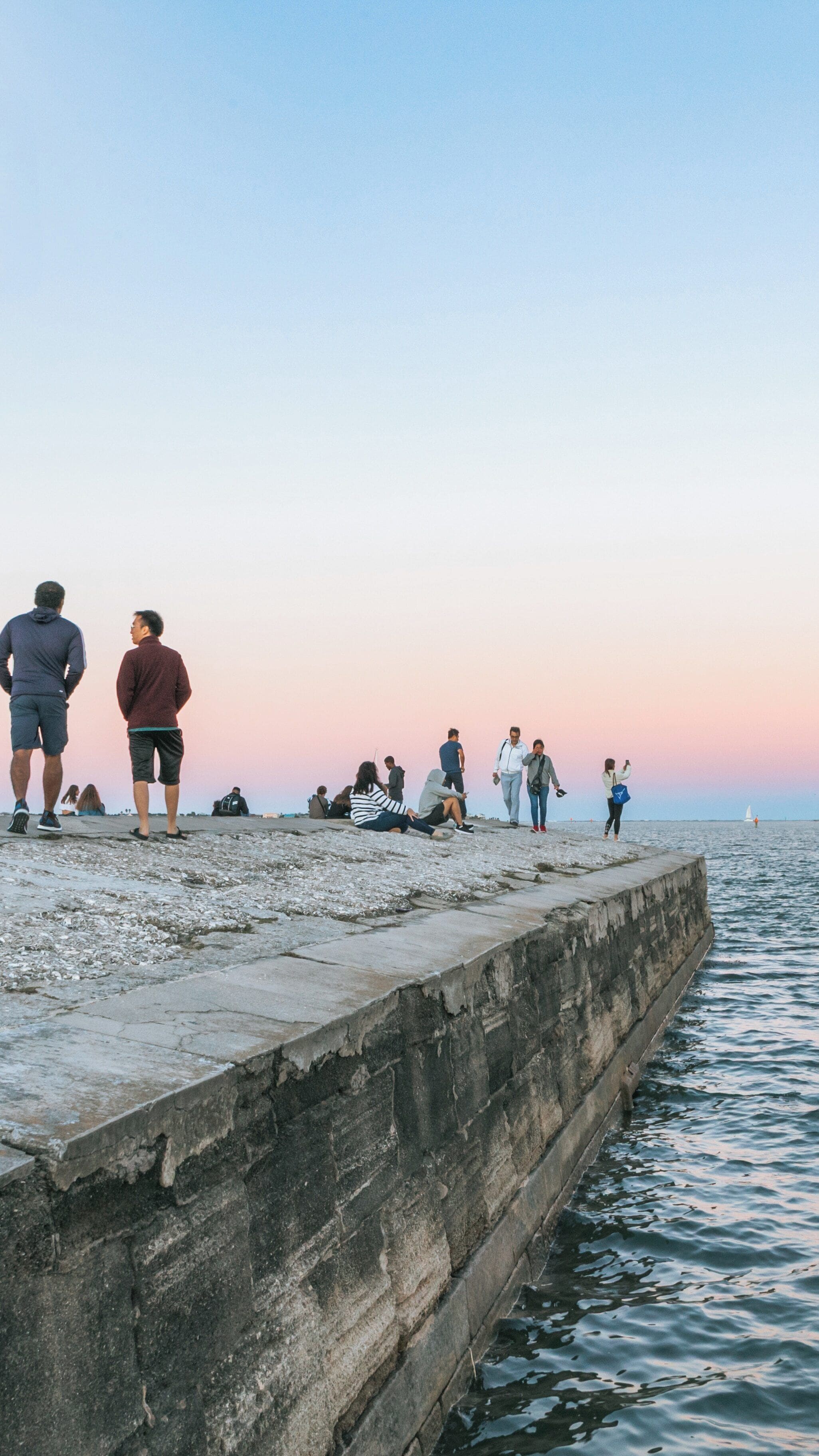 Visitors enjoy the sunset view over Castillo de San Marcos National Monument in St. Augustine, Florida with the calm waters of the Atlantic Ocean