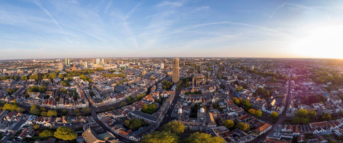 A panoramic view of a city with historic architecture, a prominent church, and a modern skyscraper.