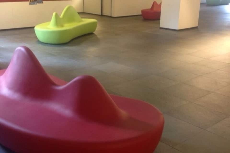 Un interior moderno con zonas de estar de formas únicas y colores vibrantes.