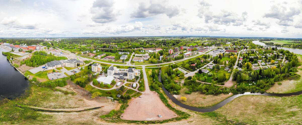 A river winding through a town with buildings and greenery.