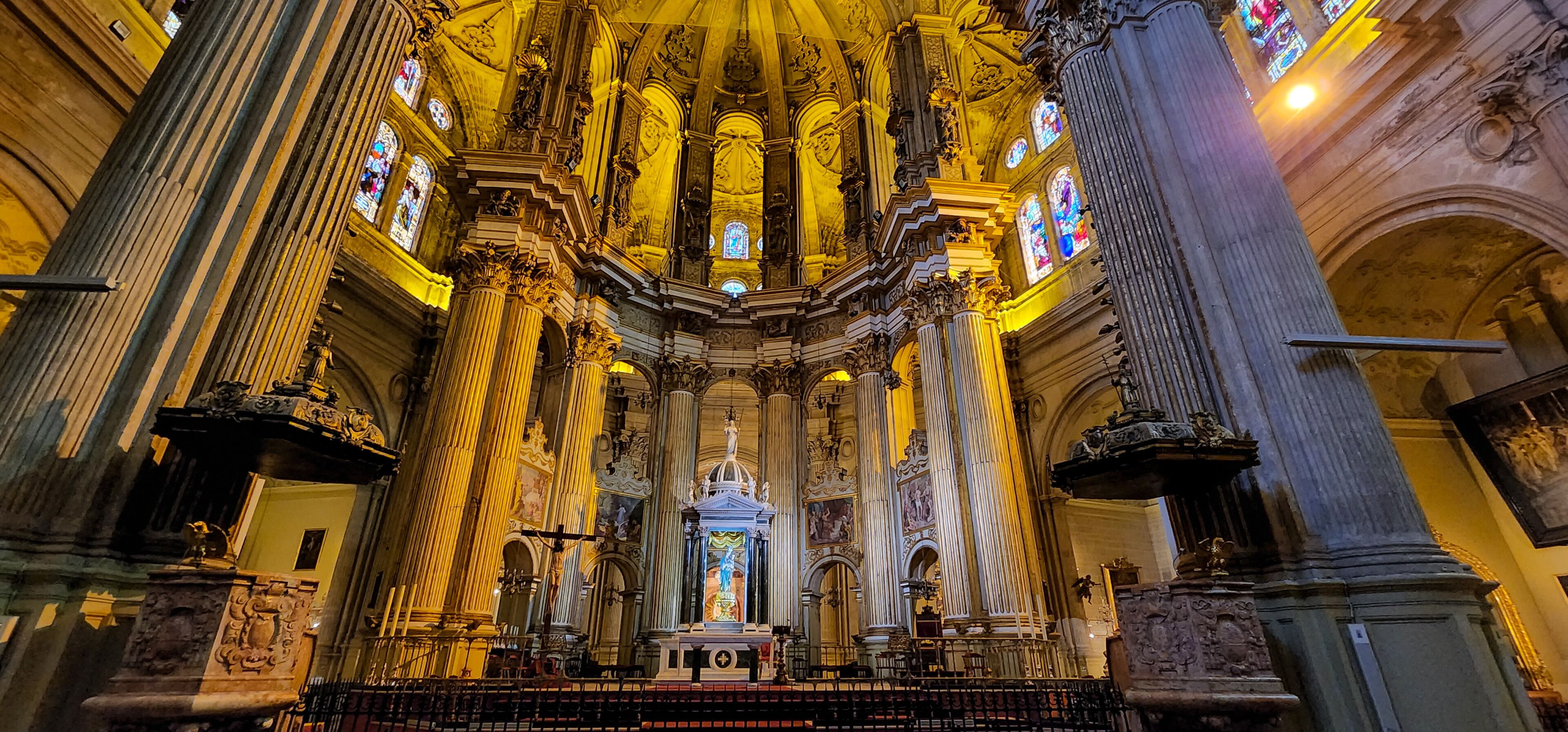 A grand cathedral interior with ornate columns, stained glass windows, and a central altar.