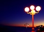 A street lamp with three globes against a twilight sky.