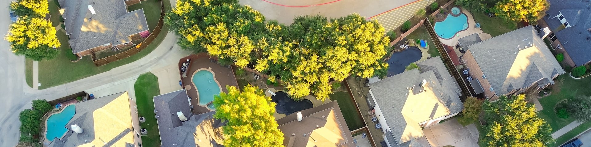 Panorama aerial view suburban houses with swimming pools and colorful fall foliage in Coppell, suburbs Dallas, Texas, large detached single-family houses, fast growing real estate housing market