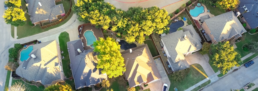 Panorama aerial view suburban houses with swimming pools and colorful fall foliage in Coppell, suburbs Dallas, Texas, large detached single-family houses, fast growing real estate housing market