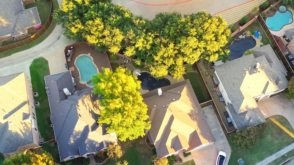 A residential area with houses, a swimming pool, and a road.