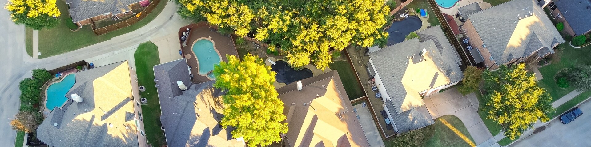Panorama aerial view suburban houses with swimming pools and colorful fall foliage in Coppell, suburbs Dallas, Texas, large detached single-family houses, fast growing real estate housing market