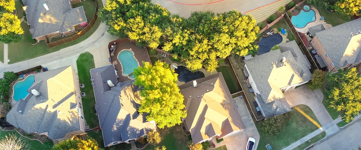 A residential area with houses, a swimming pool, and a road.