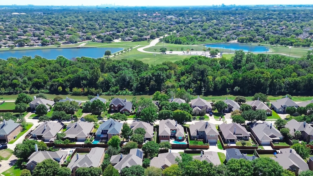 A residential area with houses, a golf course, and two lakes.