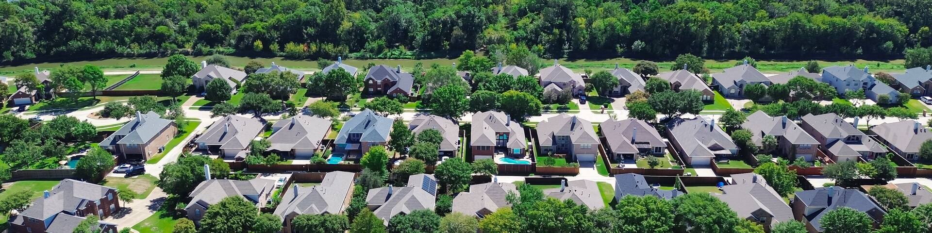 A residential area with houses, a golf course, and two lakes.