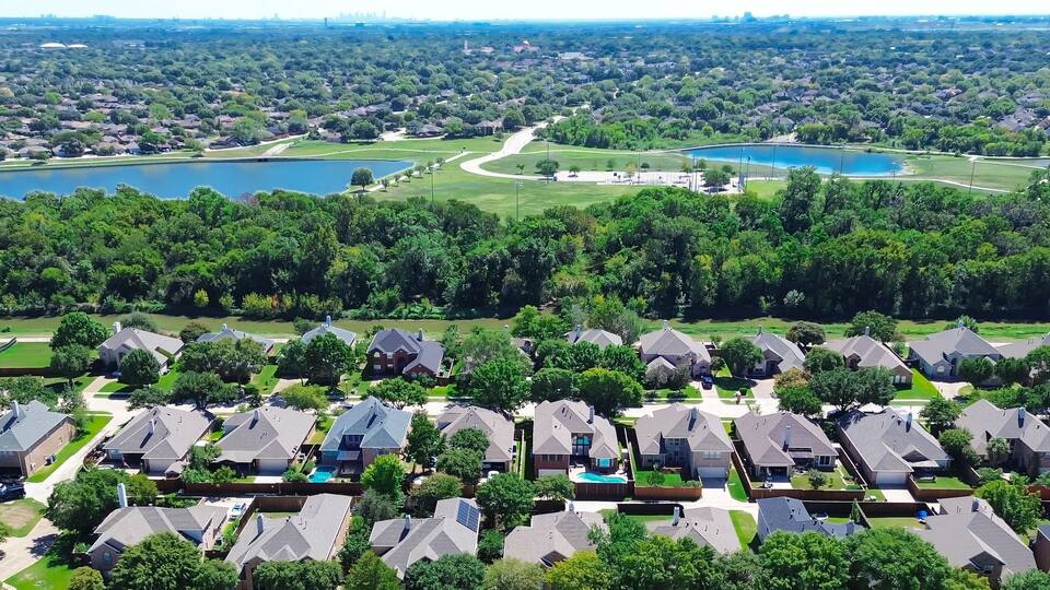 A residential area with houses, a golf course, and two lakes.