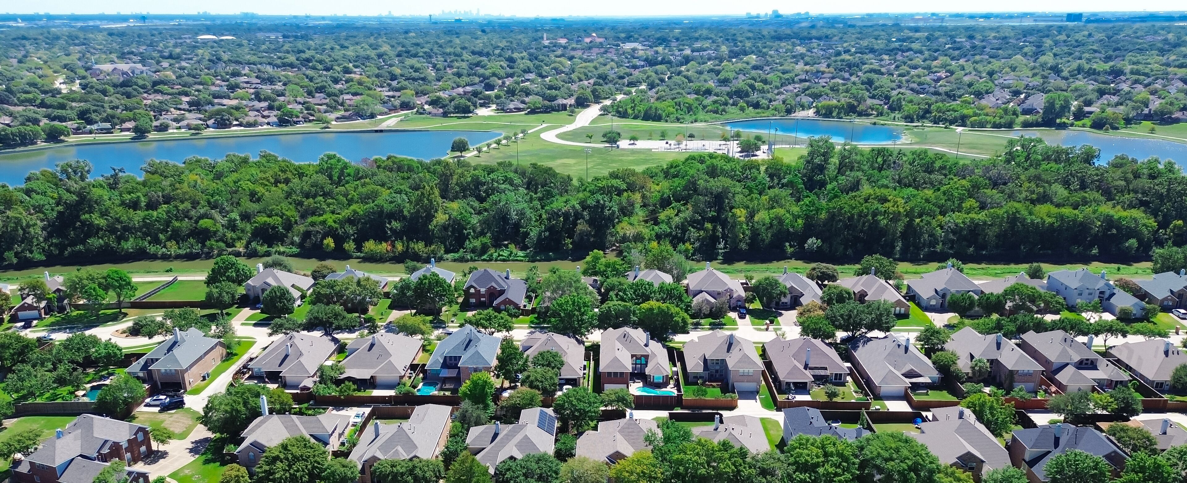 A residential area with houses, a golf course, and two lakes.
